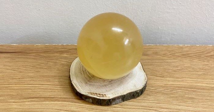 quả cầu canxit vàng trên khúc gỗ